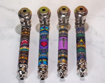 Può includere: Quattro pipe in metallo con disegni decorativi. Ogni pipa ha un corpo color argento e una manica fantasia. Le maniche presentano un fungo, un cuore, una libellula e un simbolo dell'occhio. Le pipe sono progettate per fumare.