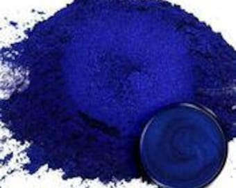 May include: A pile of deep blue mica powder with a small container of the same powder in the foreground.