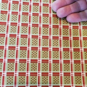 May include: Red and green plaid fabric with a white grid pattern and small red dots.