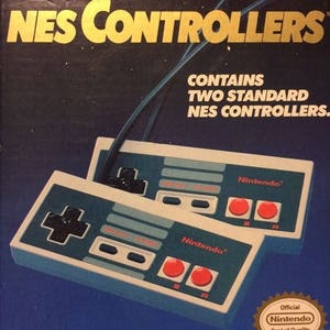 May include: A box for two NES controllers, featuring a close-up of the controllers. The controllers are white with gray buttons and red A and B buttons. The box has a blue background with stars and the text "NES CONTROLLERS" in gold letters. The box also includes the text "CONTAINS TWO STANDARD NES CONTROLLERS." and the Nintendo logo.