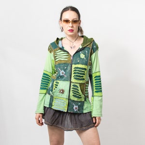 Peut inclure: Un sweat à capuche vert en patchwork avec une fermeture éclair. Le sweat est composé de différents morceaux de tissu vert et bleu cousus ensemble, créant un design unique et coloré.