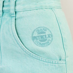 Puede incluir: Pantalones cortos de mezclilla azul claro con un logotipo bordado en blanco que dice "Jeans Petrol Club".