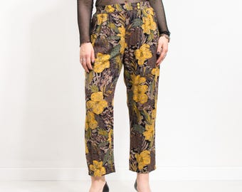 Könnte beinhalten: Hochtaillierte Hose mit auffälligem Blumenmuster in Gelb, Braun und Grün. Die Hose hat einen geraden Beinverlauf und einen Knopfverschluss. Der Stoff wirkt weich, möglicherweise Vintage.
