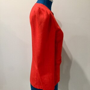 May include: A bright red blazer with a slightly puffed shoulder and a single button closure.