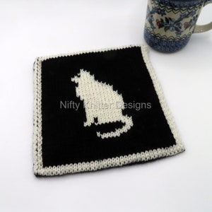 May include: A black knitted coaster with a white knitted cat silhouette in the center. The coaster has a white border. The text "Nifty Knitter Designs" is printed in white on the black background.