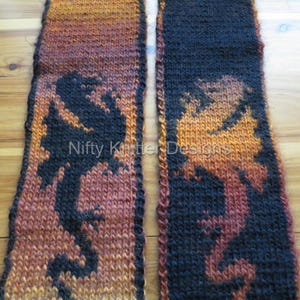 May include: Two knitted scarves with a black and orange ombre pattern. The scarves are knit in a simple stitch and feature a black silhouette of a dragon.