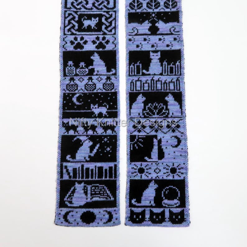 May include: A knitted scarf with a repeating pattern of black cat silhouettes and other mystical symbols on a light purple background. The scarf features various designs, including cats, moons, stars, and books. The text "Nitty Knitter Designs" is visible.