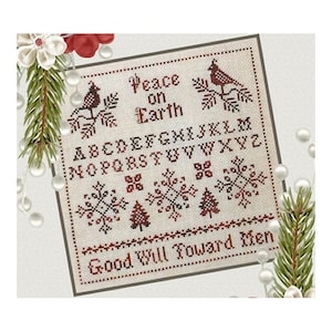 May include: A cross-stitch sampler with a cream background and red and brown embroidery. The sampler features the text "Peace on Earth, Good Will Toward Men" and the alphabet. There are also images of snowflakes and pine trees.