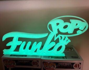 El logotipo personalizado de Funko Pop Display brilla en verde en la oscuridad.