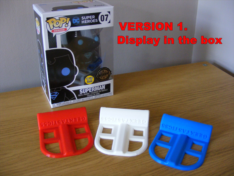 May include: Three 3D printed plastic display stands in red, white, and blue. The stands are designed to hold a Funko Pop figure in a box. The text "GEEKTASTIC55" is printed on each stand.