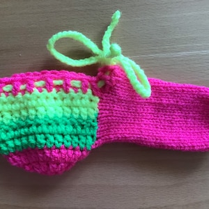 May include: A pink, green and yellow crocheted sock with a neon green string tie.