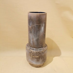 Könnte beinhalten: Eine Keramikvase mit einem gefleckten braunen und weißen Überzug. Die Vase hat einen zylindrischen Körper mit einem ausgestellten Boden.