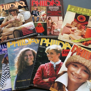 Könnte beinhalten: Eine Sammlung von Vintage-Zeitschriften der Marke "Phildar" mit farbenfrohen Titelseiten, die Strick- und Häkelprojekte, Mode und Wohnaccessoires zeigen. Die Zeitschriften sind in verschiedenen Sprachen gehalten, mit dem prominenten "Phildar"-Logo.