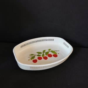 May include: White oval serving tray with a cherry design. The tray has a decorative border of small holes around the edge.