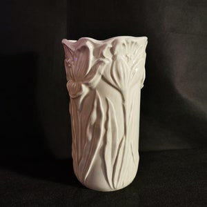 以下が含まれることがあります： スタイリッシュなチューリップのデザインが浮き彫りになった白いセラミックの花瓶