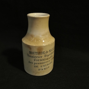 Puede incluir: Un tarro de mostaza de cerámica blanca con un esmalte marrón. El tarro tiene texto negro que dice "MOUTARDE de MAILLE Vinaigrier Distillateur FOURNISSEUR des premieres Conserves DE L'EUROPE PARIS".
