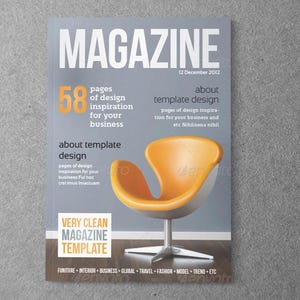 Può includere: Un modello di copertina per rivista con la parola MAGAZINE in grandi lettere bianche, la data 12 dicembre 2012 e il testo 58 pages of design inspiration for your business. Una sedia gialla con base argentata è centrata sulla copertina.