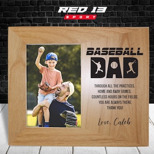 May include: A wooden picture frame with a photo of a father and son playing baseball. The frame has a baseball-themed design with the text "Baseball Dad" and a message about the father's dedication to the sport. The text "Love, Caleb" is at the bottom of the frame.