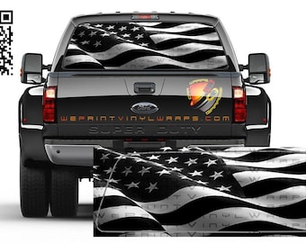 May include: Black and white American flag decal for a truck window. The decal is printed on a clear vinyl material and features a waving flag design. The decal is applied to the rear window of a black pickup truck. The truck has the words "SUPER DUTY" printed on the tailgate. The decal is available for purchase from the website "WEPRINTVINYLWRAPS.COM".