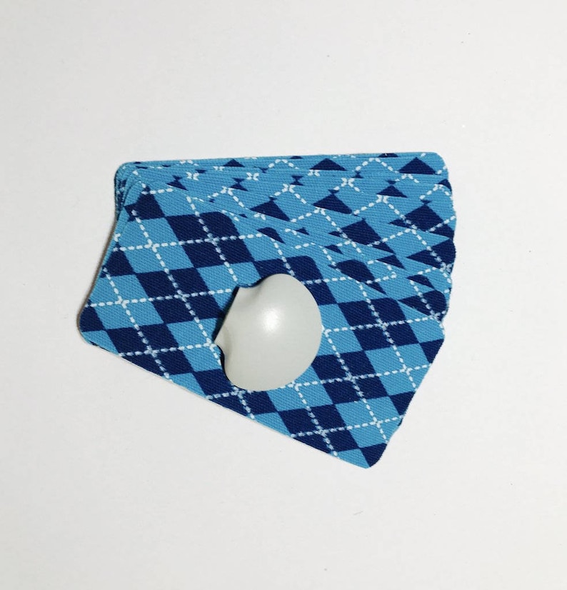 Op de afbeelding: Een kaartspel met een blauw-wit geruit patroon. De kaarten zijn gewaaid en een wit hartvormig object is bovenop het spel gelegd.