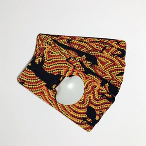 Op de afbeelding: Een stapel kleurrijke kaarten met een zwart en geel patroon. De kaarten zijn dubbelgevouwen en hebben een witte cirkel in het midden.
