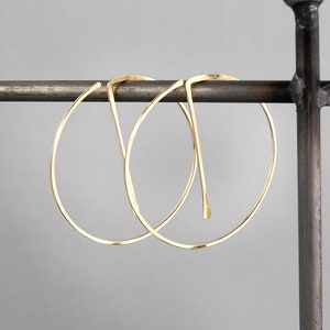 Peut inclure: Deux cr&eacute;oles en or suspendues &agrave; un support en m&eacute;tal. Les cr&eacute;oles sont simples et &eacute;l&eacute;gantes, avec une finition lisse et polie.