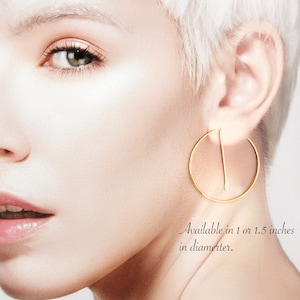 Peut inclure: Boucles d'oreilles cr&eacute;oles en or avec une barre droite au centre. Disponibles en 1 ou 1,5 pouces de diam&egrave;tre.