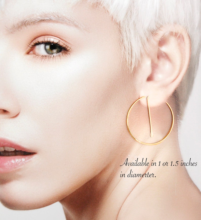 Peut inclure: Boucles d'oreilles cr&eacute;oles en or avec une barre droite au centre. Disponibles en 1 ou 1,5 pouces de diam&egrave;tre.