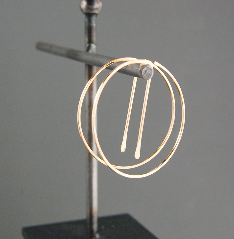 Peut inclure: Boucles d'oreilles cr&eacute;oles en or avec un design &agrave; double cr&eacute;ole. Les cr&eacute;oles sont reli&eacute;es par un fil fin.