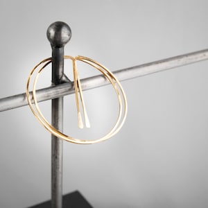 Peut inclure: Boucles d'oreilles cr&eacute;oles en or avec un design &agrave; double cercle. Les boucles d'oreilles sont pr&eacute;sent&eacute;es sur un support en m&eacute;tal.