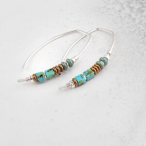 Puede incluir: Un par de pendientes de aro de plata con cuentas turquesa y cobre. Los pendientes son simples y elegantes, y ser&iacute;an un gran regalo para cualquier ocasi&oacute;n.