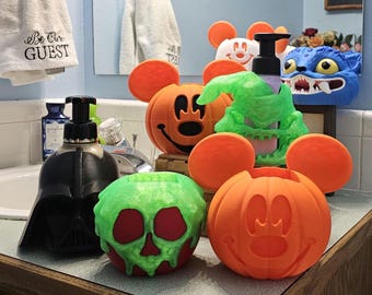 May include: A collection of novelty soap dispensers in various Halloween and Disney-themed designs. Includes a Darth Vader head, Mickey Mouse pumpkins, a green skull, and a blue monster. The dispensers are orange, black, green, and blue.