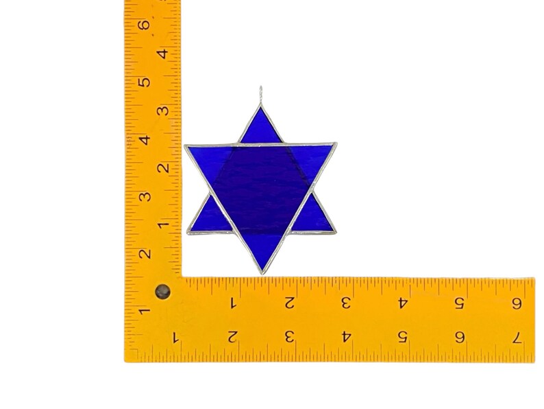 May include: A blue stained glass Star of David ornament with silver lead cames. The ornament is approximately 4 inches in diameter.