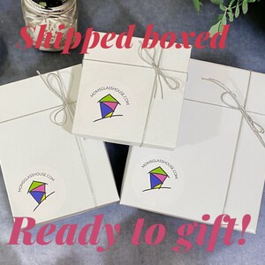 May include: Three white gift boxes with a silver ribbon tied around each box. Each box has a colorful logo sticker with the text "MOMSGlassHOUSE.COM" and a stylized image of a house. The text "Shipped boxed" is written in red at the top of the image and the text "Ready to gift!" is written in red at the bottom of the image.