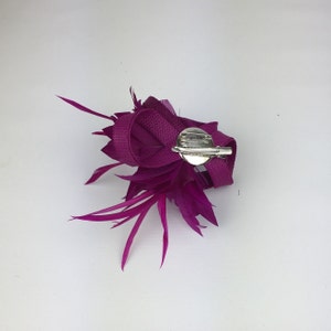 May include: A magenta feather and ribbon flower hair clip with a silver clasp.