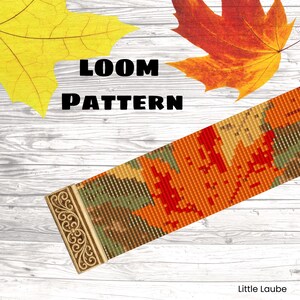 Könnte beinhalten: Ein gewebtes Perlenarmband mit einem herbstlichen Blattmuster in Orange-, Rot-, Grün- und Brauntönen. Das Band ist mit einem verzierten, rechteckigen Metallverschluss versehen, der ein detailliertes Schnörkelmuster auf der Oberfläche aufweist.
