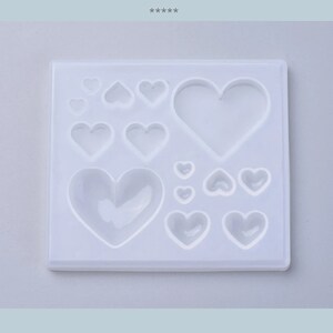 Puede incluir: Un molde de silicona blanco con 11 cavidades en forma de coraz&oacute;n de diferentes tama&ntilde;os. El molde est&aacute; dise&ntilde;ado para crear artesan&iacute;as de resina.