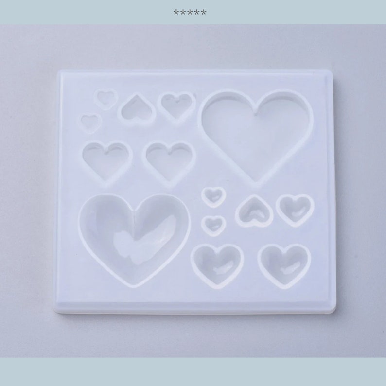 Puede incluir: Un molde de silicona blanco con 11 cavidades en forma de coraz&oacute;n de diferentes tama&ntilde;os. El molde est&aacute; dise&ntilde;ado para crear artesan&iacute;as de resina.