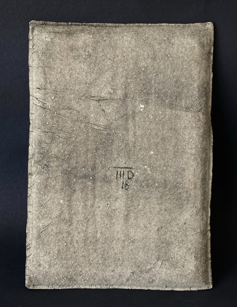 Pu&ograve; includere: Una piastrella di ceramica rettangolare, testurizzata e di colore grigio con il testo "HID 18" stampato in nero.