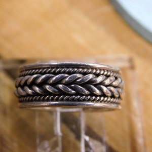 May include: A silver ring with a braided design.