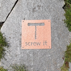 May include: A brown wooden sign with a silhouette of a corkscrew and the text "screw it".