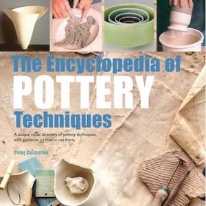 Puede incluir: El libro The Encyclopedia of Pottery Techniques de Peter Cosentino presenta una portada con imágenes de vasijas de cerámica, modelado de arcilla y herramientas de alfarería. El título está impreso en letras grandes blancas y azules sobre un fondo de tela beige.