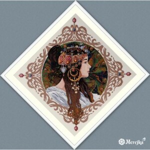 May include: Cross-stitch artwork depicting a woman in profile, wearing a jeweled headdress and large earrings. The image is set within a diamond-shaped frame with ornate detailing. The colour palette includes brown, cream, and red accents.
