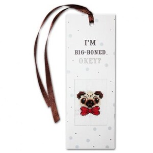 May include: A white bookmark with a brown ribbon and a cross-stitched pug wearing a red bow tie. The bookmark has the text "I'M BIG-BONED. OKEY?" and small grey polka dots.