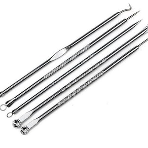May include: A set of five stainless steel tools for removing blackheads and blemishes. The tools have different shapes and sizes, including a loop, a pointed tip, and a flat edge.
