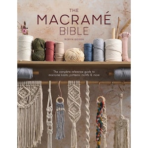 May include: The Macramé Bible by Robyn Gough is a book featuring a collection of yarn spools in various colors on a shelf above several hanging macramé projects. The text reads: The Macramé Bible, Robyn Gough, The complete reference guide to macrame knots, patterns, motifs & more.