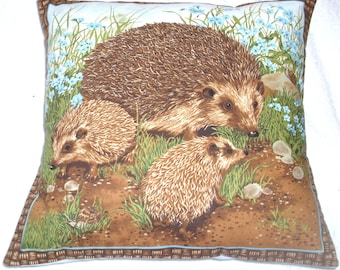 A Hedgehog and her two youngsters among pretty blue flowers in a garden cushion