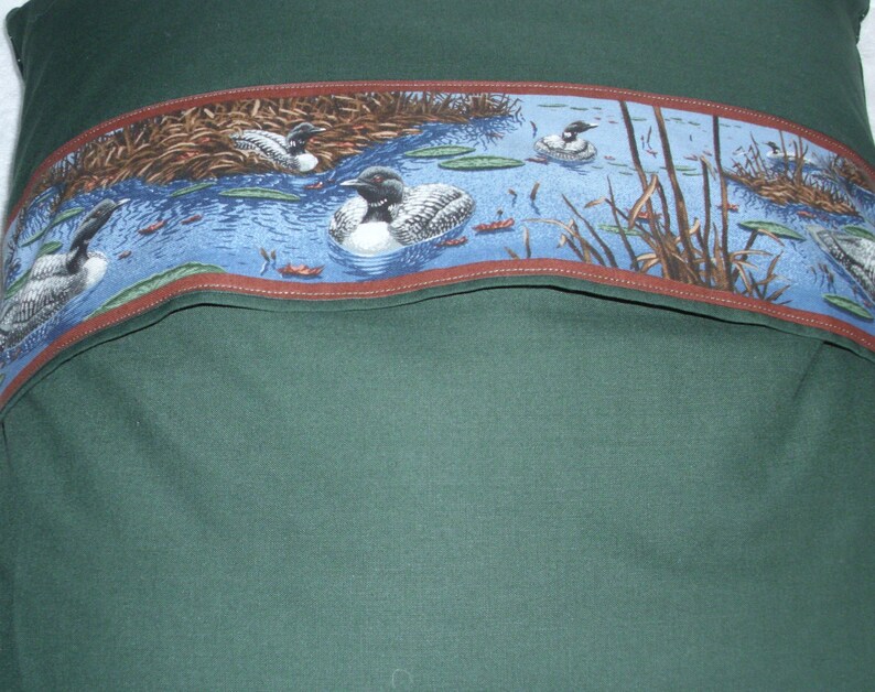 Loon with chicks on a lake cushion