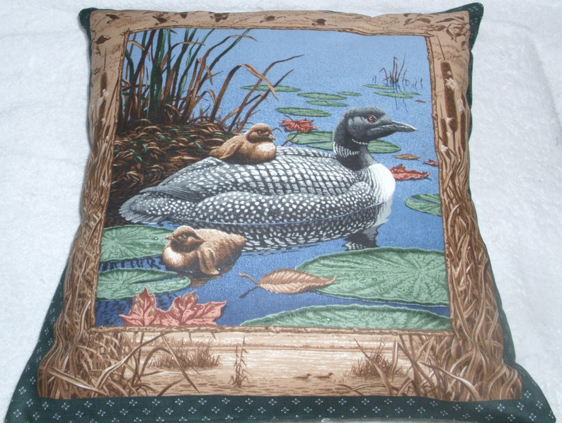 Loon with chicks on a lake cushion