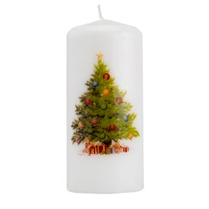 Puede incluir: Vela blanca en forma de pilar con un diseño de árbol de Navidad. El árbol está decorado con adornos rojos, verdes y dorados y una estrella en la parte superior. También hay regalos en la base del árbol.
